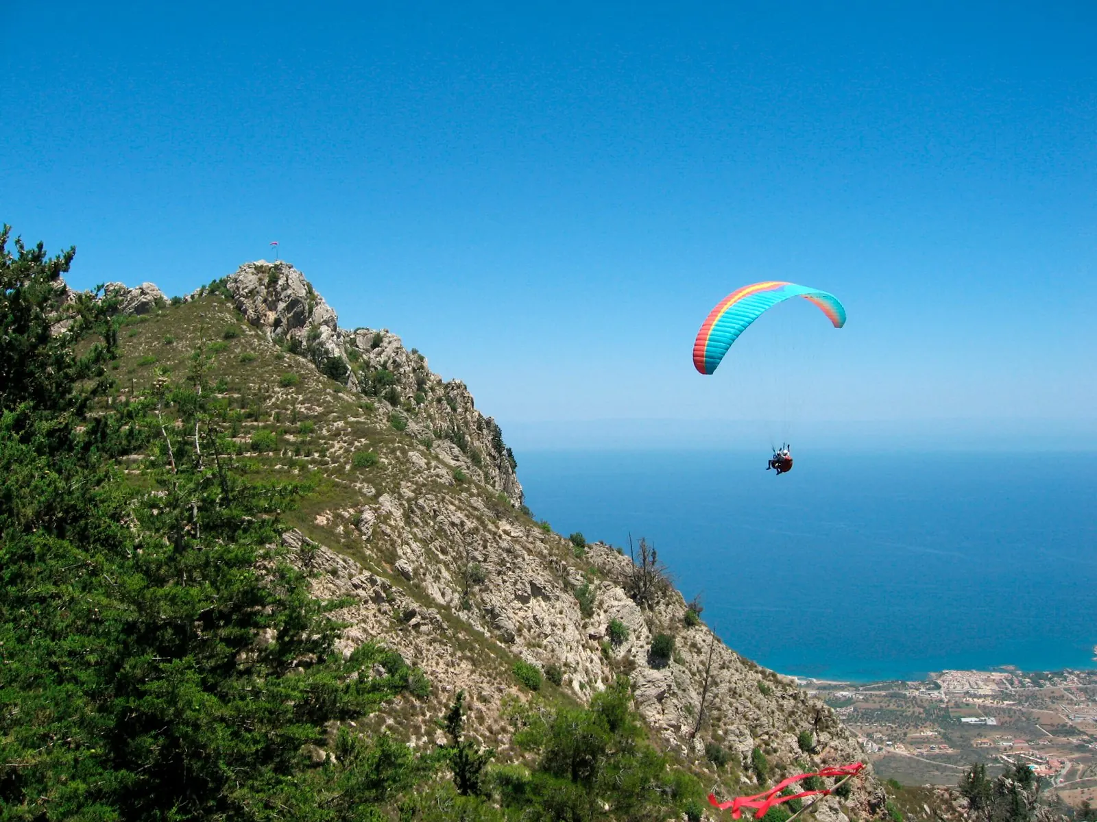 Parapente au-dessus du lac d’Annecy près d’une crête rocheuse